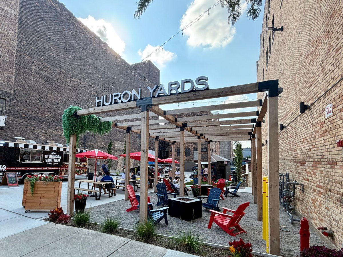 The Huron Yards courtyard, with its wooden pergola, outdoor seating, and food truck